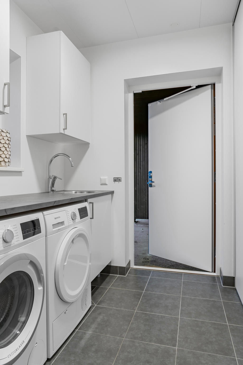 Tvättstuga med bra arbetsytor och groventré 