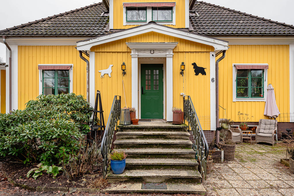 Entré och uteplats invid huset med kvällssol