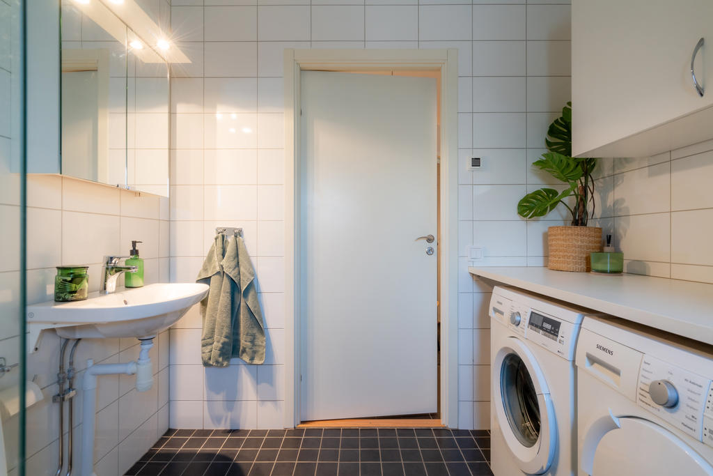 Tvättdel med både tvättmaskin och torktumlare samt överskåp för smidig förvaring