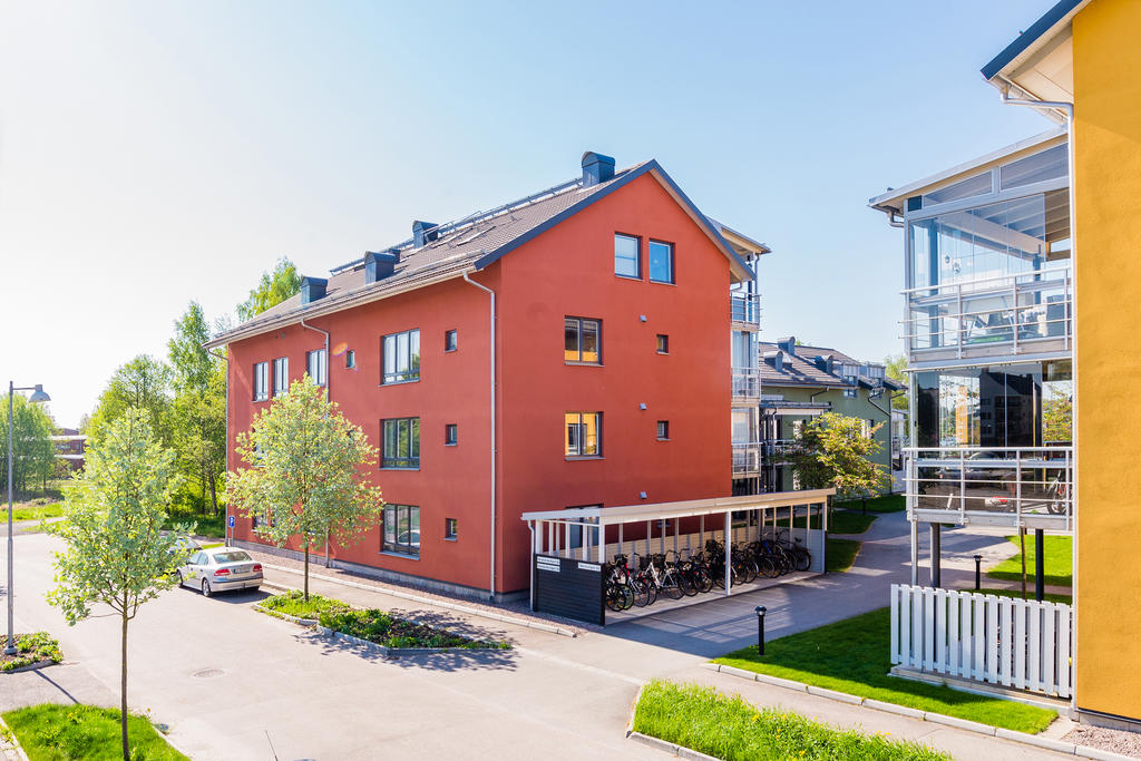 Gästparkering ute vid gatan och cykelförvaring utanför byggnaden.