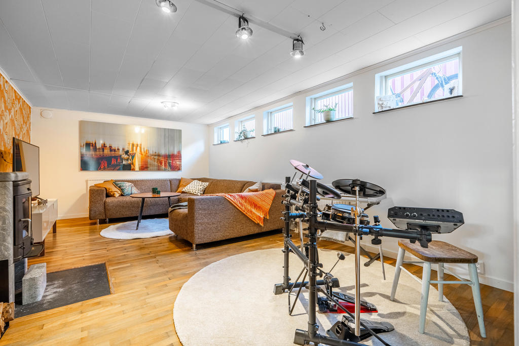 Trivsamt allrum i källarplan med kamin som ger värme och en härlig mysfaktor.