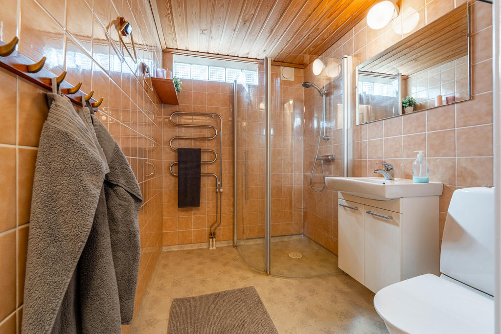 Badrum i källarplan utrustat med wc, handfat, dusch och handdukstork.