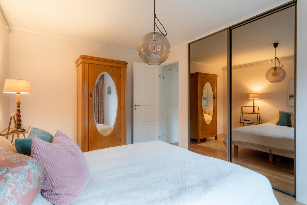 Rymliga skjutdörrsgarderober med speglar i stora sovrummet