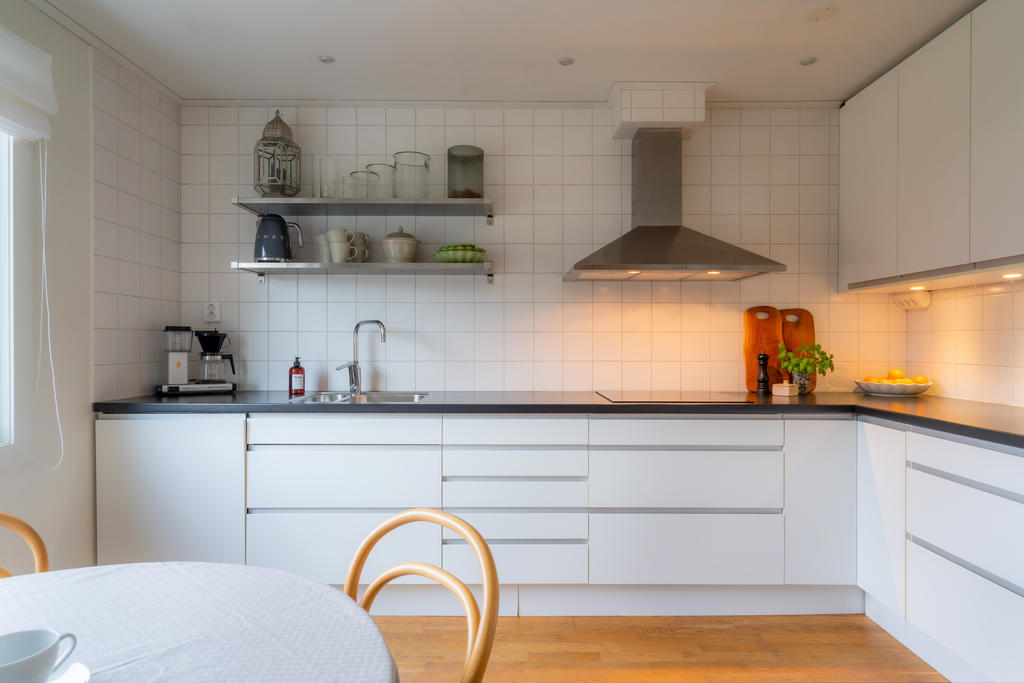 Öppna hyllor, kakel och spotlights ger karaktär till köket