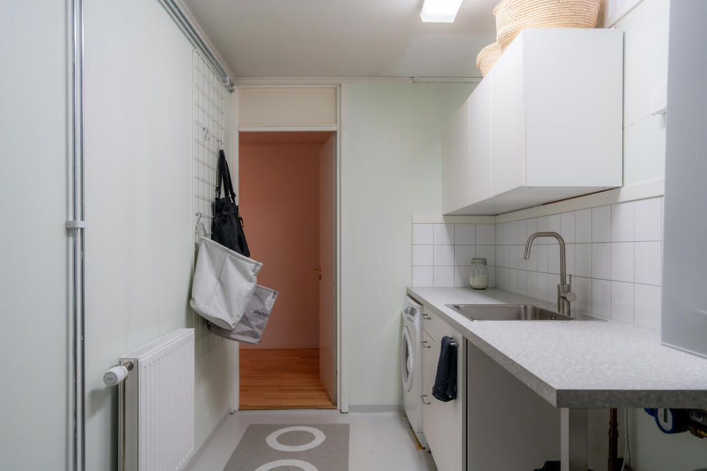 Tvättstuga med mycket förvaring, tvättho & bänk