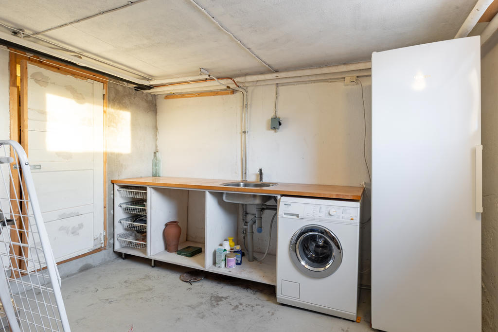 Tvättstuga med tvättmaskin från Miele och torkskåp