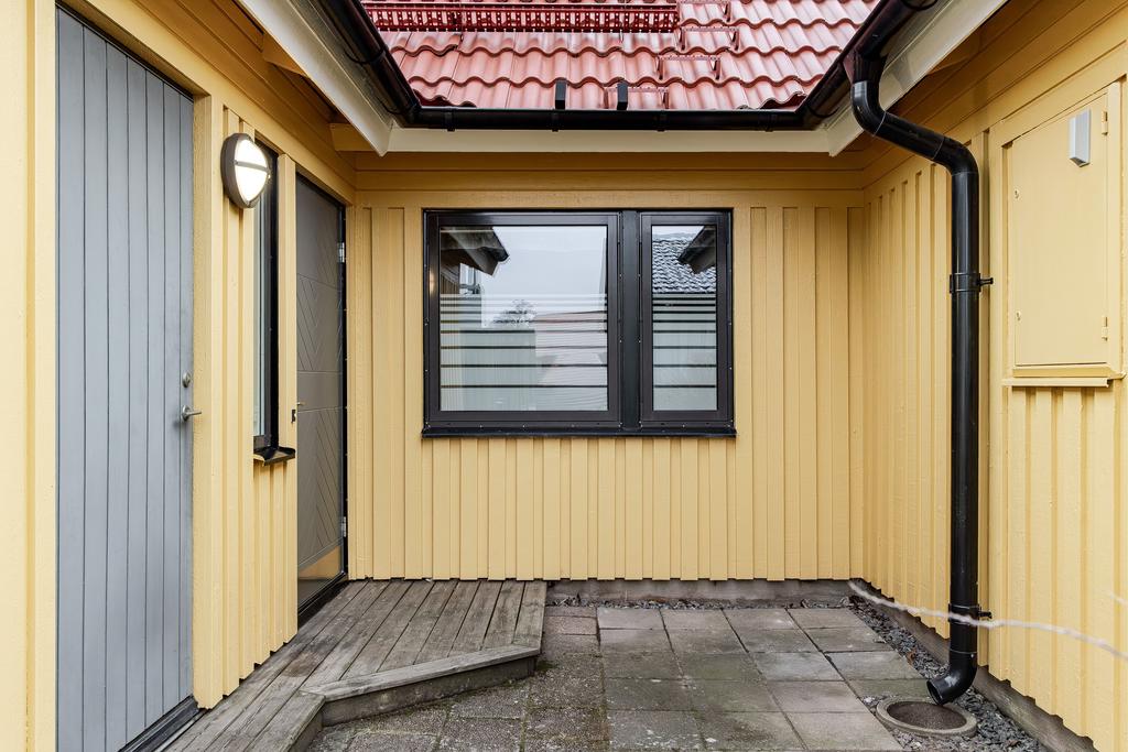 Stenlagd uteplats på framsidan, här finns även ett förråd
