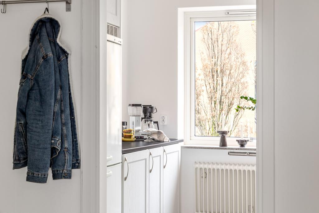 Fin vy från hallen in mot köket – ljus och fräsch helhet med moderna material.