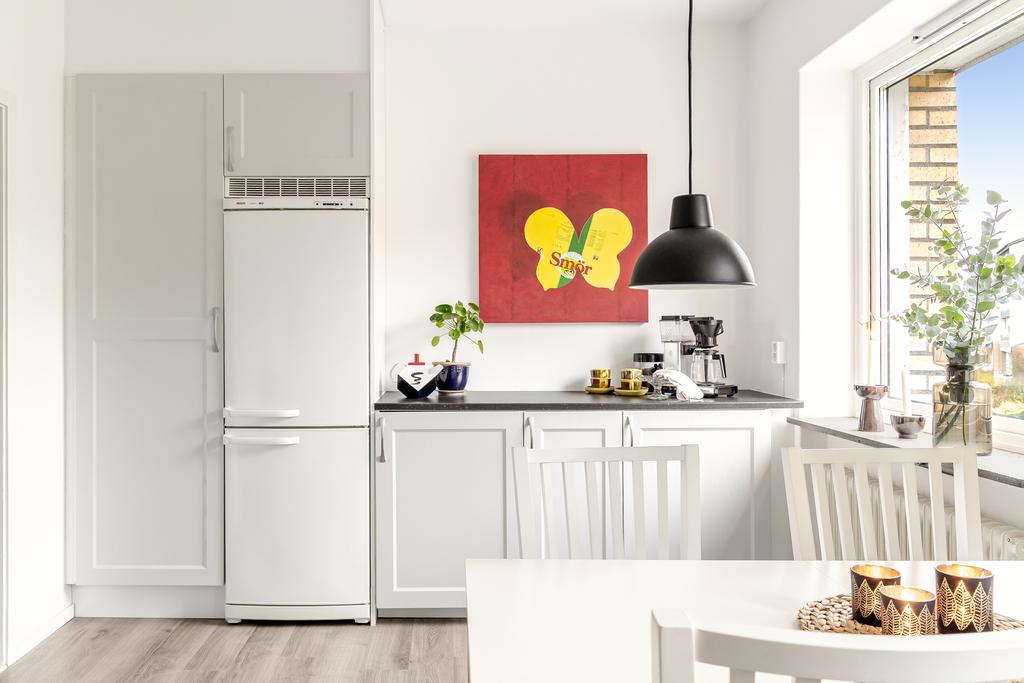 Trivsamt kök med plats för matbord och en luftig känsla tack vare stora fönster.