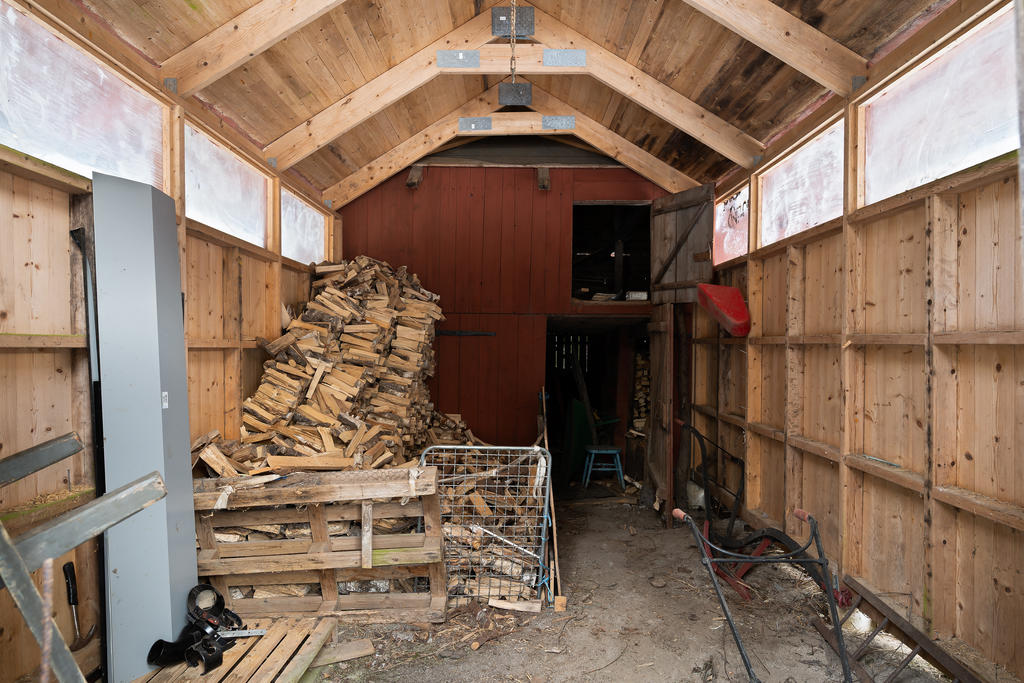 Förrådsbyggnad/vedbod.
Vid dörröppningen i bilden finns ytterligare vedförvaring.