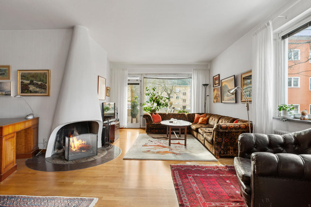 Underbart vardagsrum med en fungerande öppen spis