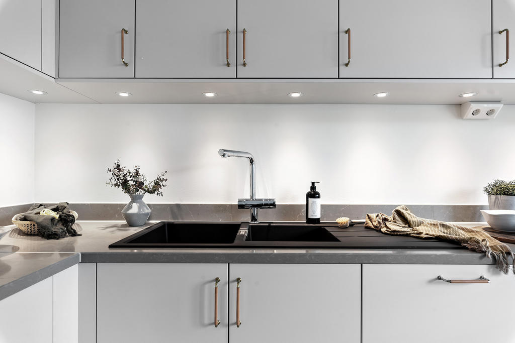 Ljusgrått kök och snygg bänkskiva av kompositsten. Exempelbild från liknande bostad.