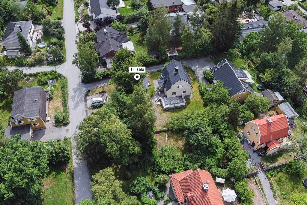 Fastigheten med parkering vid gatan och en fin plan tomt runt huset