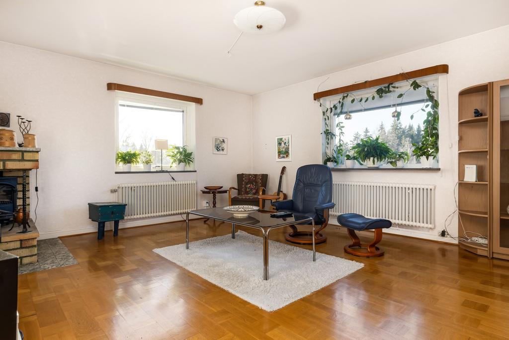 Vardagsrum med öppen spis samt utgång till balkong.