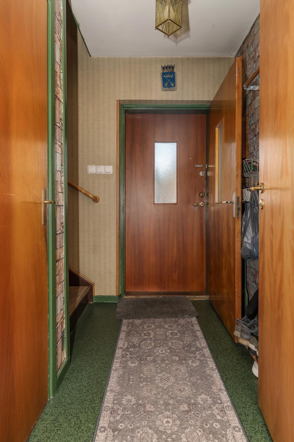 Hall med uppgång till övre plan och ner till källaren.