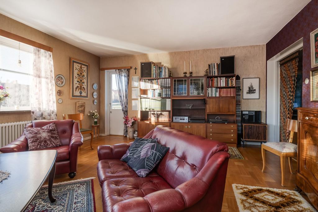 Vardagsrum med öppen spis med insats samt utgång till balkong.