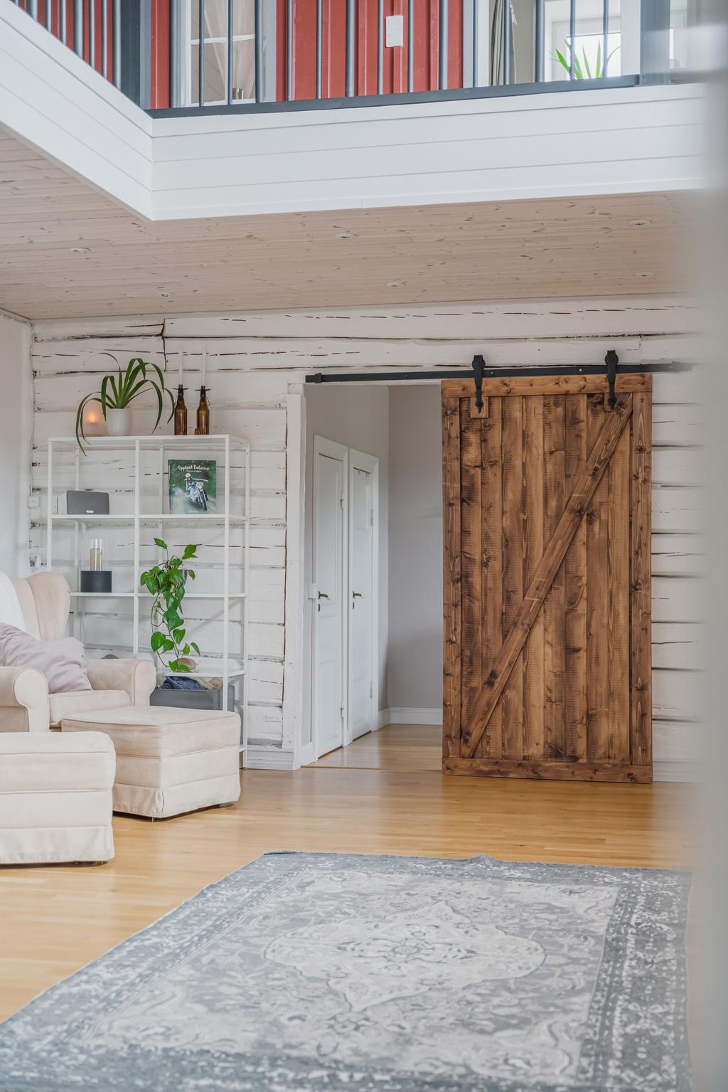 Rum i anslutning till entréplan med skjutdörr i trä som ger en rustik karaktär och smidig avskärmning.