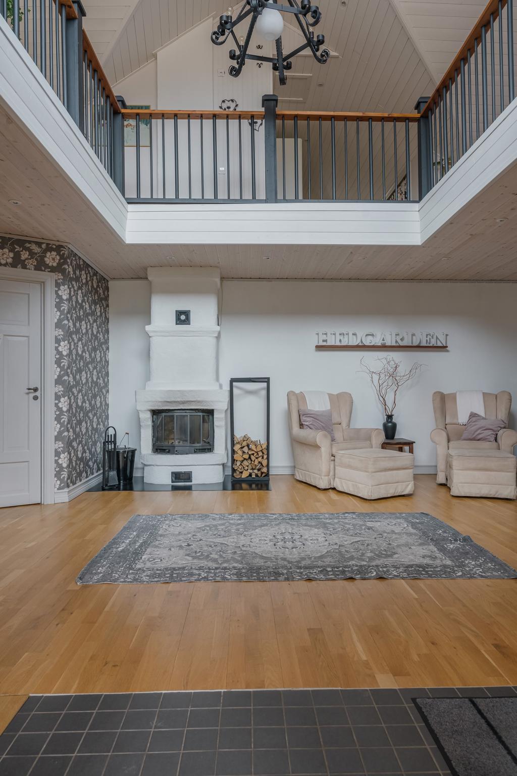 Kamin centralt placerad i entréhallen som bidrar till både värme och en trivsam atmosfär.