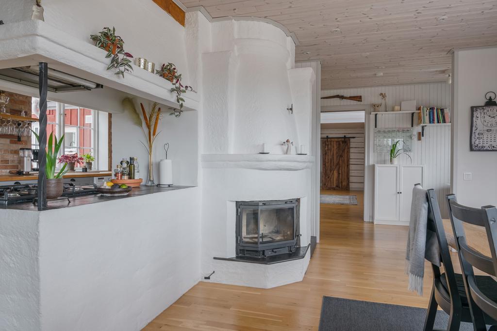 Kamin i anslutning till kök och matplats som skapar en varm och inbjudande miljö.