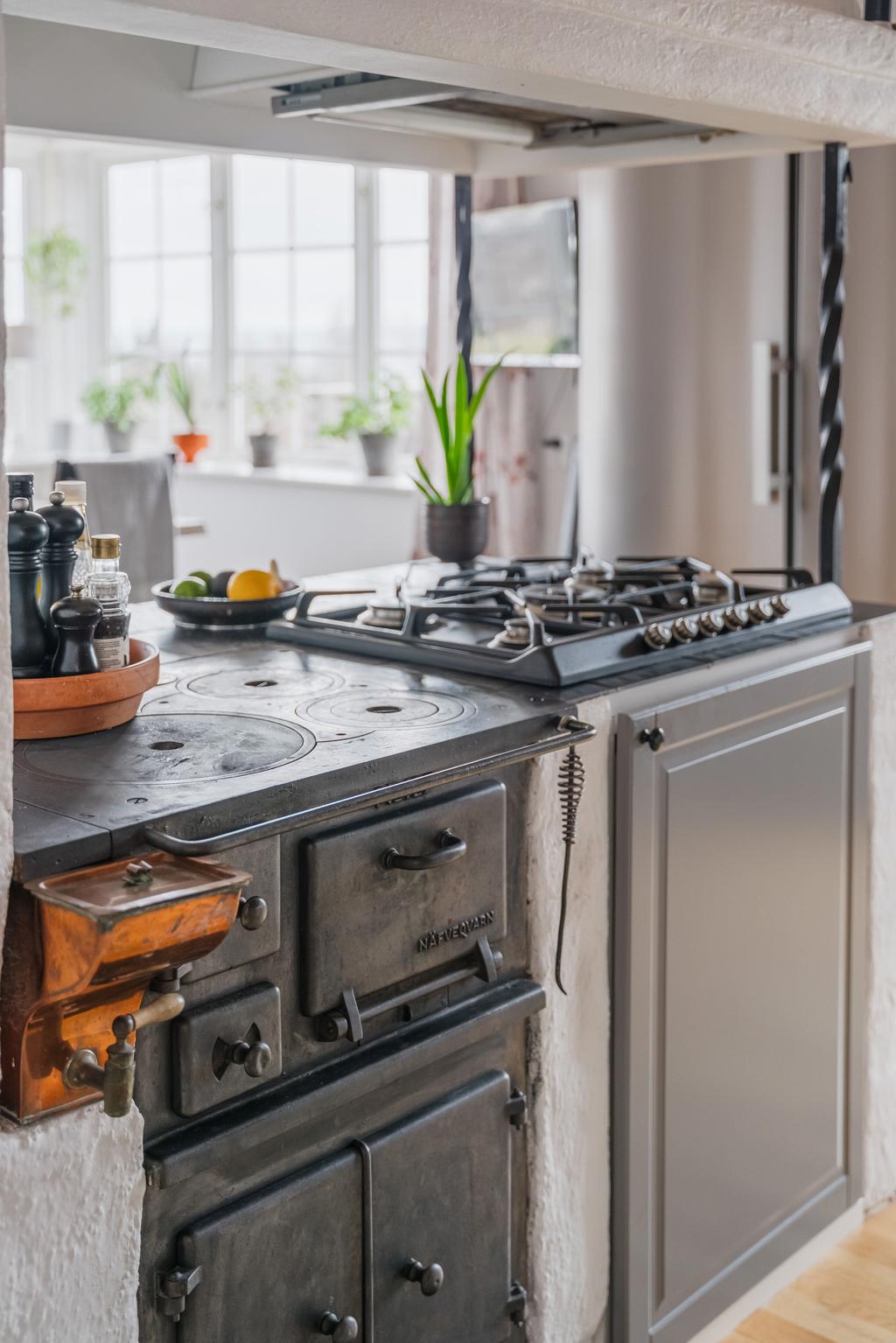 Detaljbild spis och vedspis i köket.