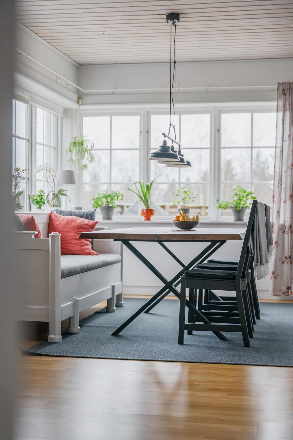 Matplats med generöst ljusinsläpp från stora fönsterpartier och plats för både matbord och kökssoffa.