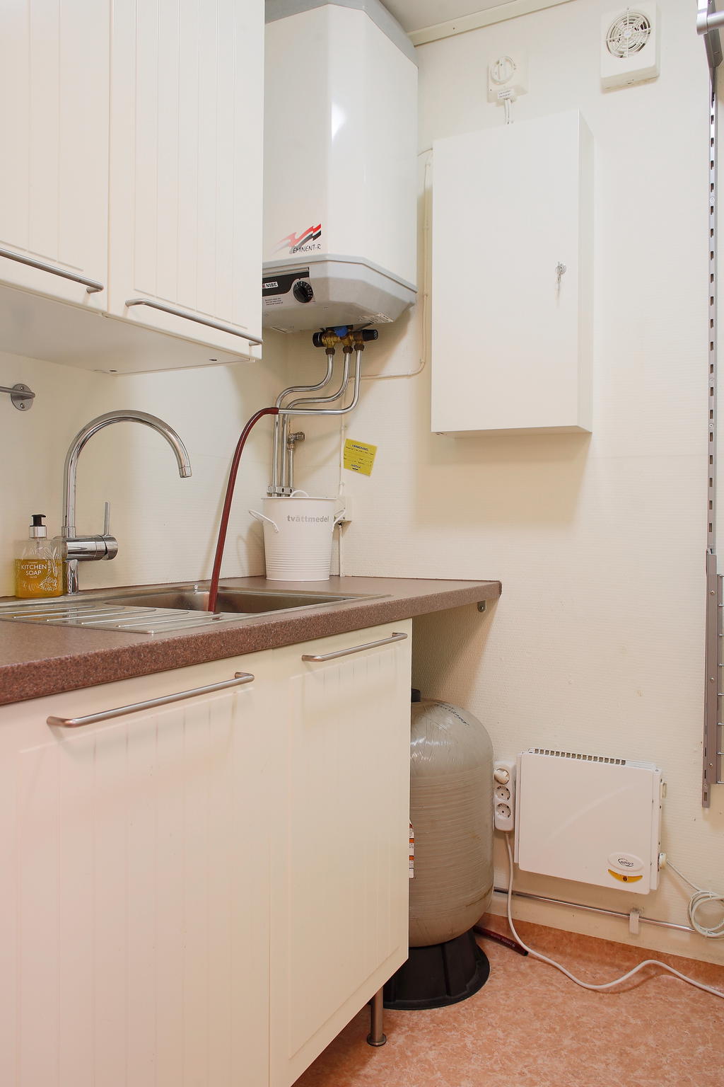 Tvättavdelning med tvättho och skåpförvaring