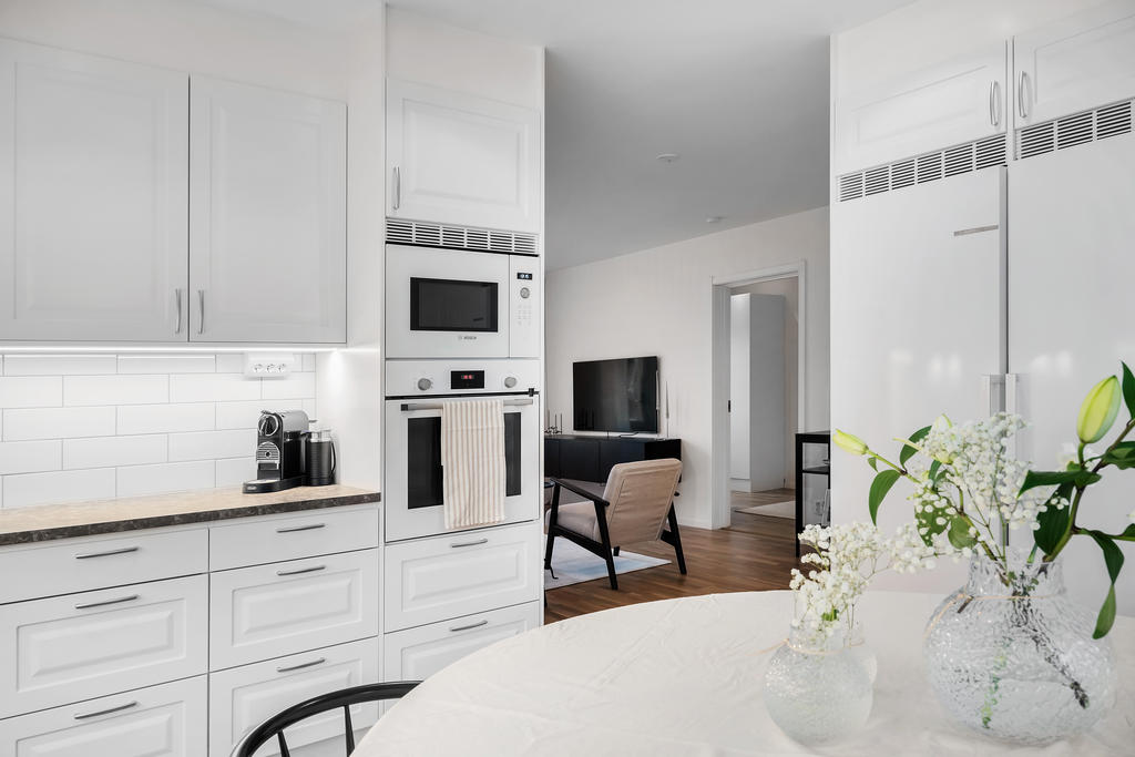 Halvöppen planlösning från kök mot vardagsrum gör att du kan sitta ostört men ändå få en rymlig känsla.