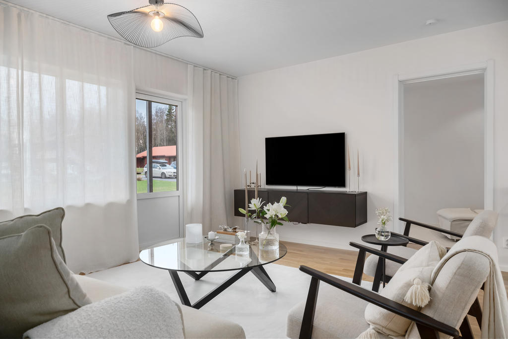 Vardagsrummet rymmer stor soffgrupp och tack vare stora fönster ges ett härligt ljusinsläpp.