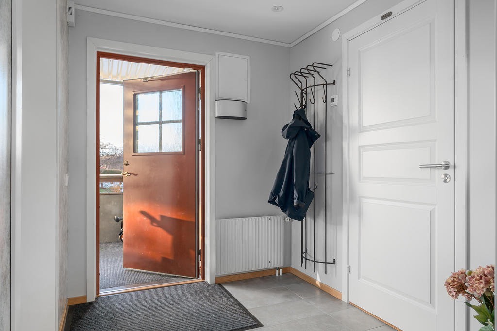 Hall med snyggt klinkers och golvvärme samt plats för ytterkläder och skor