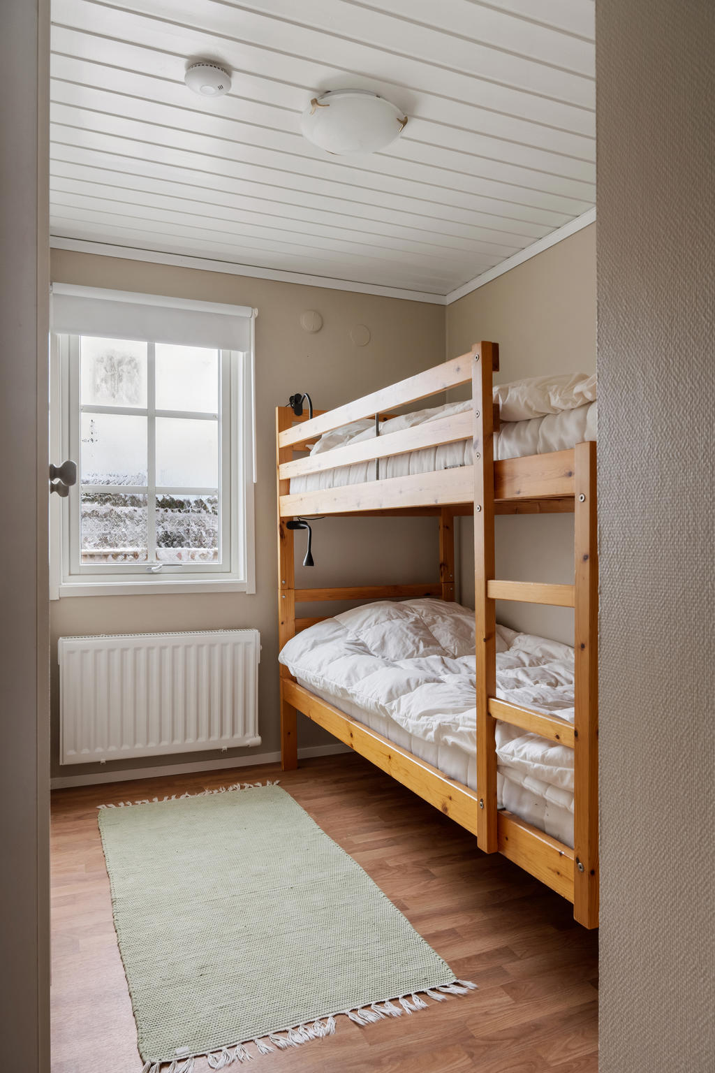 Sovrum 2 på nedre plan är en praktisk och mångsidig yta som kan anpassas till både enkel- och dubbelbäddsarrangemang. Med tillräckligt med plats för en enkelsäng och en skrivbordshörna eller våningssäng, erbjuder rummet flexibilitet för att möta olika behov. Med närheten till hallen är det lättillgängligt och bekvämt för både boende och gäster.