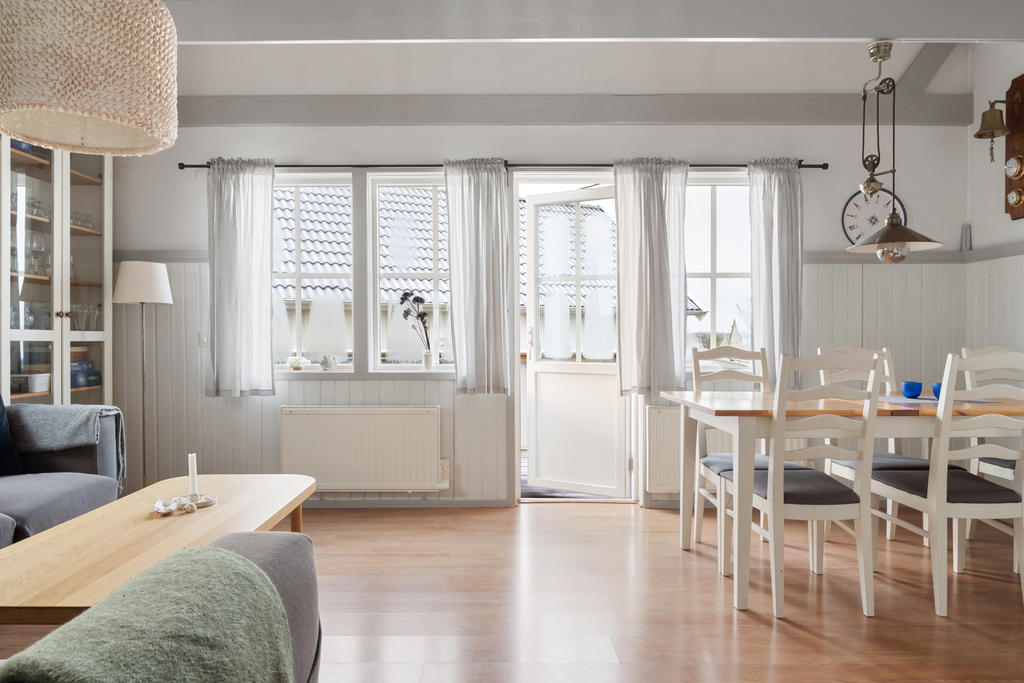Vardagsrummet är en del av en öppen planlösning med kök, utgång till terrass med bra solläge och havsglimt. Det är ljust och rymligt med flertal fönster och med gott om plats för möblering av både soffgrupp och matbord.