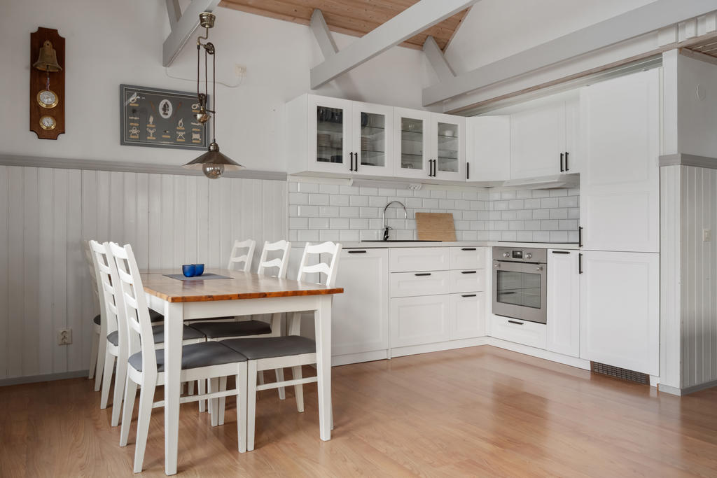 Köket i denna öppna planlösning mot vardagsrummet är en vacker och funktionell plats med högt i tak. Här finns gott om förvaring, fullt utrustat kök och väl avvägda ytor som skapar en inbjudande atmosfär.