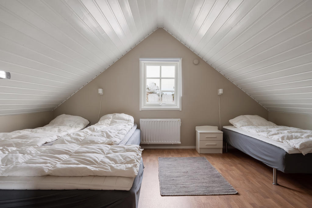 Sovrum 3 på övre plan är perfekt för en familj eller gäster med möjlighet att rymma upp till fyra bäddar. Med fönstret som ger in naturligt ljus och gott om utrymme, erbjuder rummet både funktionalitet och komfort.