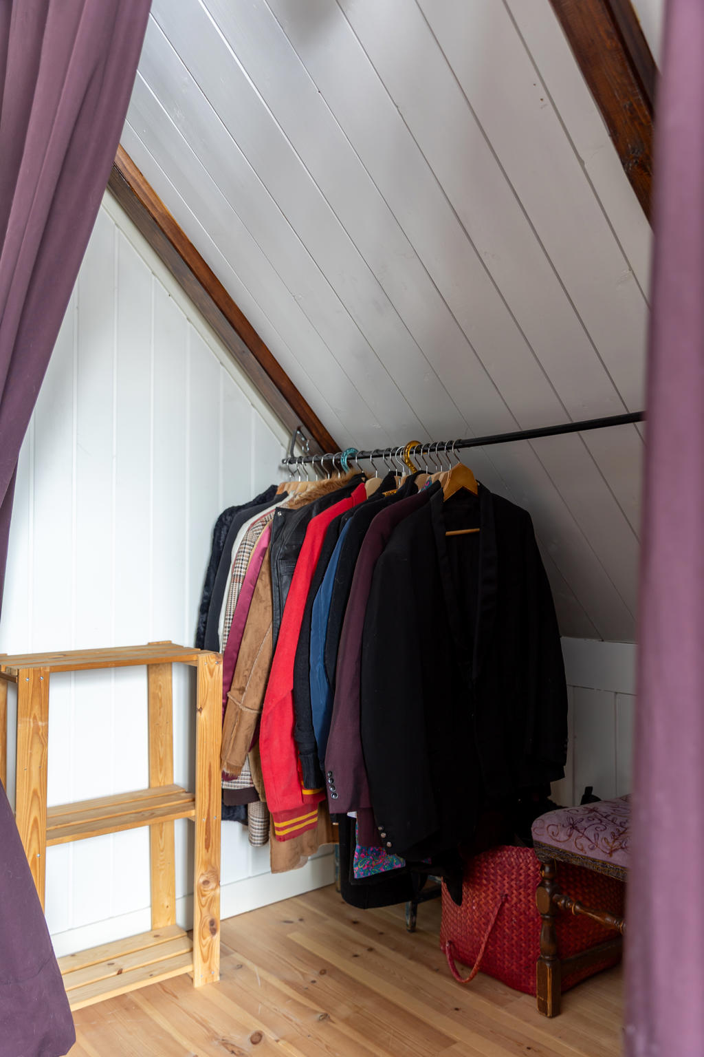 Dolt bakom gardinen gömmer sig en lång garderob. 