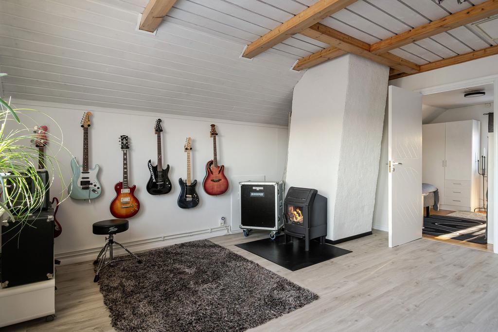 Allrummet har synliga takbjälkar och kamin