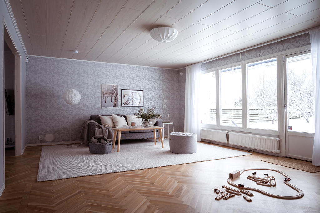 Ett vackert vardagsrum med ett golv i fiskbensparkett, som är slipat och vitlaserat.