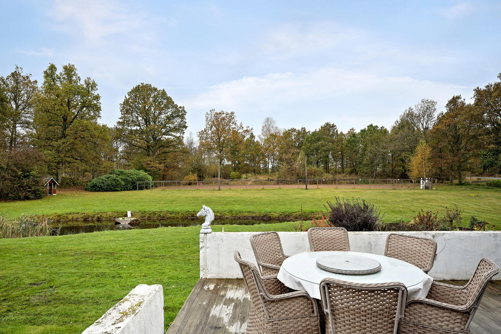 Uteplats med utsikt över dammen och paddocken
