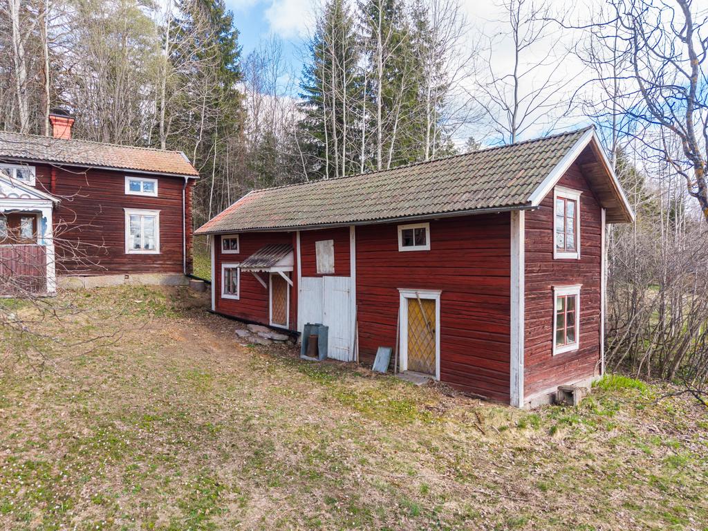 “Ladan” – äldre timmerbyggnad med storstuga, garage samt förråd med uppgång till loft.