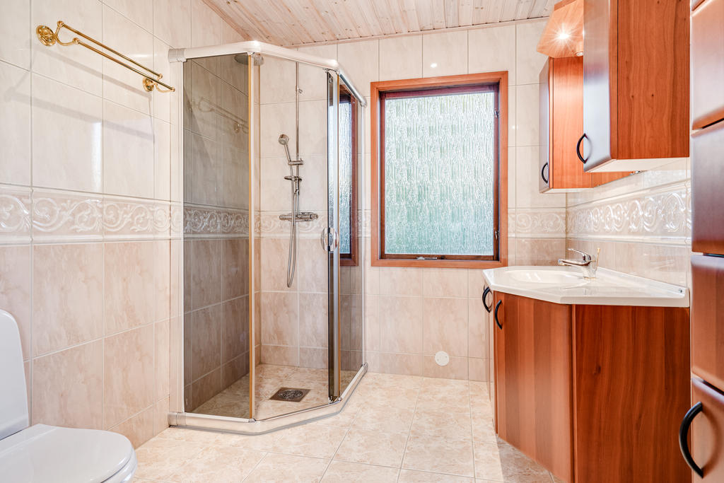 Badrum med toalett, dusch, tvättställ, el-golvvärme, spotlights.