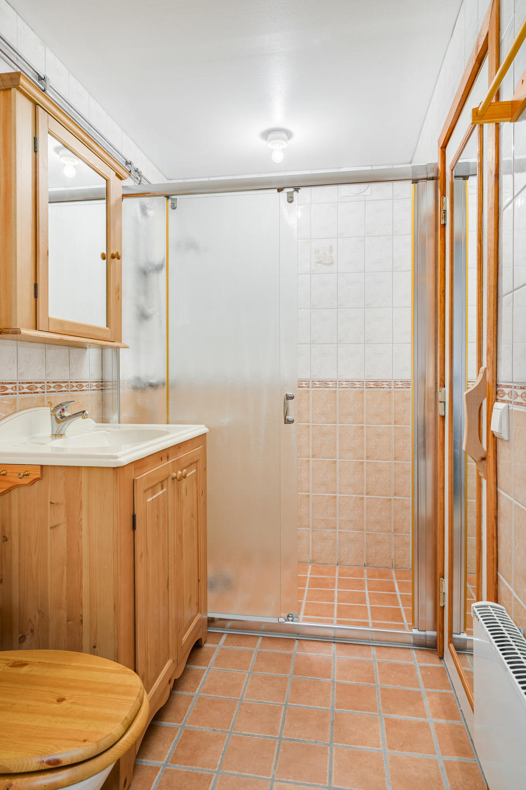 Badrum med toalett, dusch, tvättställ.