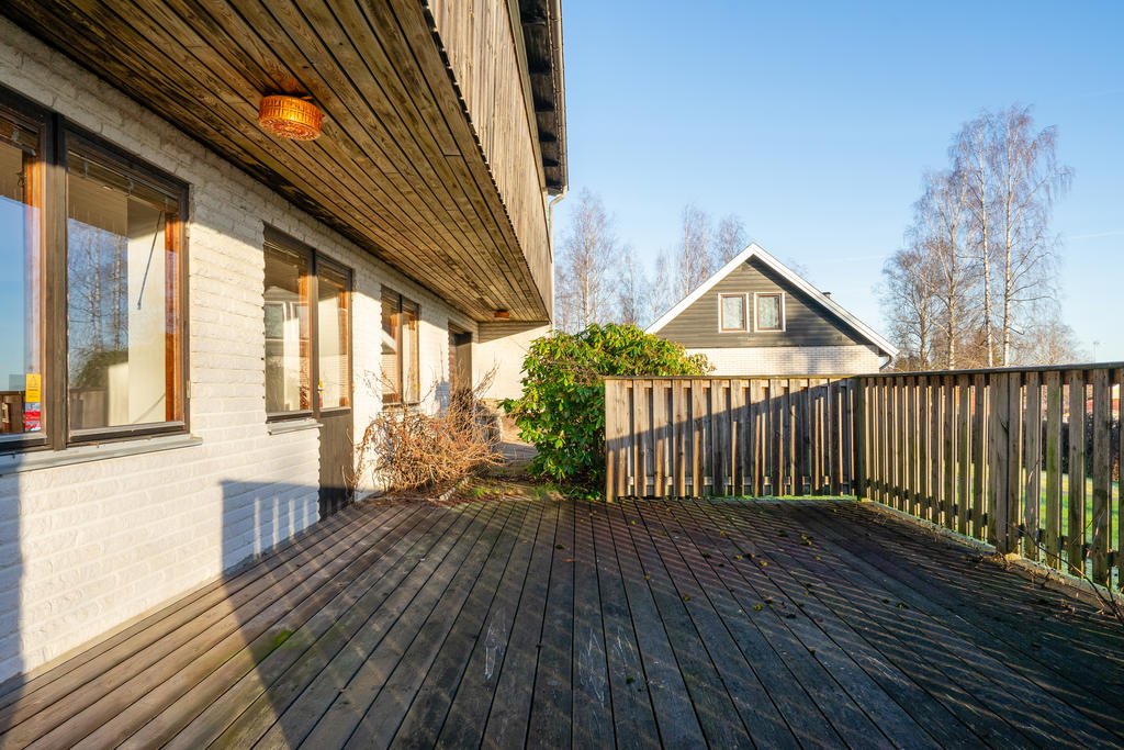 Altandäck på husets baksida med plats för umgänge.