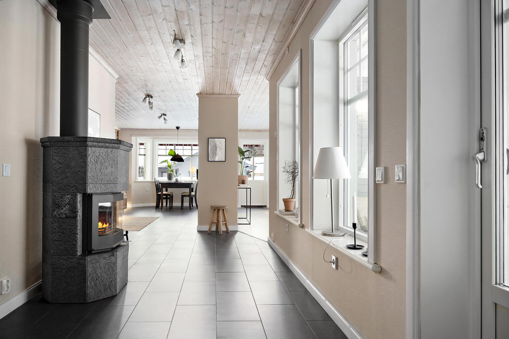 Täljstenskaminen är mycket strategiskt placerad mitt i huset och bidrar både till effektiv uppvärmning och ombonad känsla.