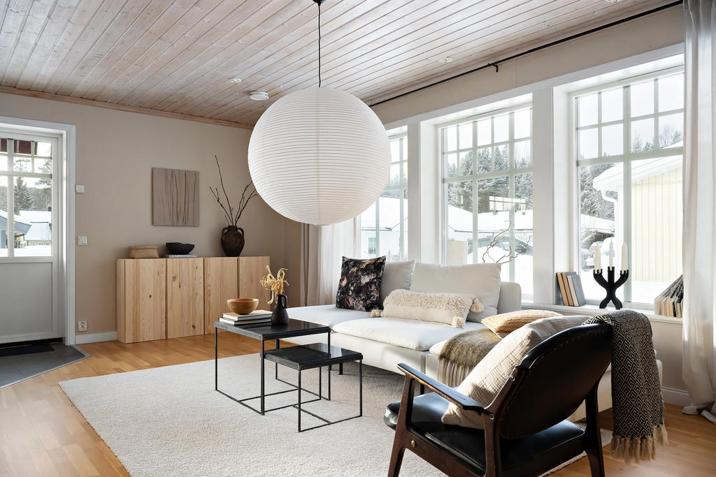 Vardagsrum med stora fönster.