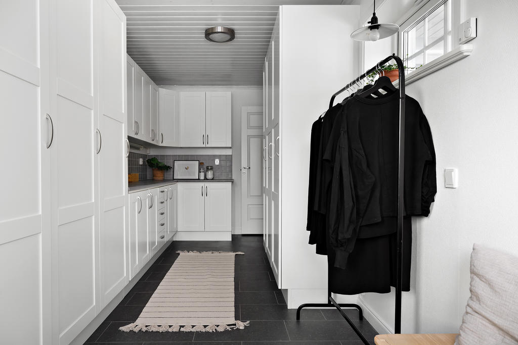 Groventré med access till garage och tvättstuga. Här finns massor av förvaring i garderober. 