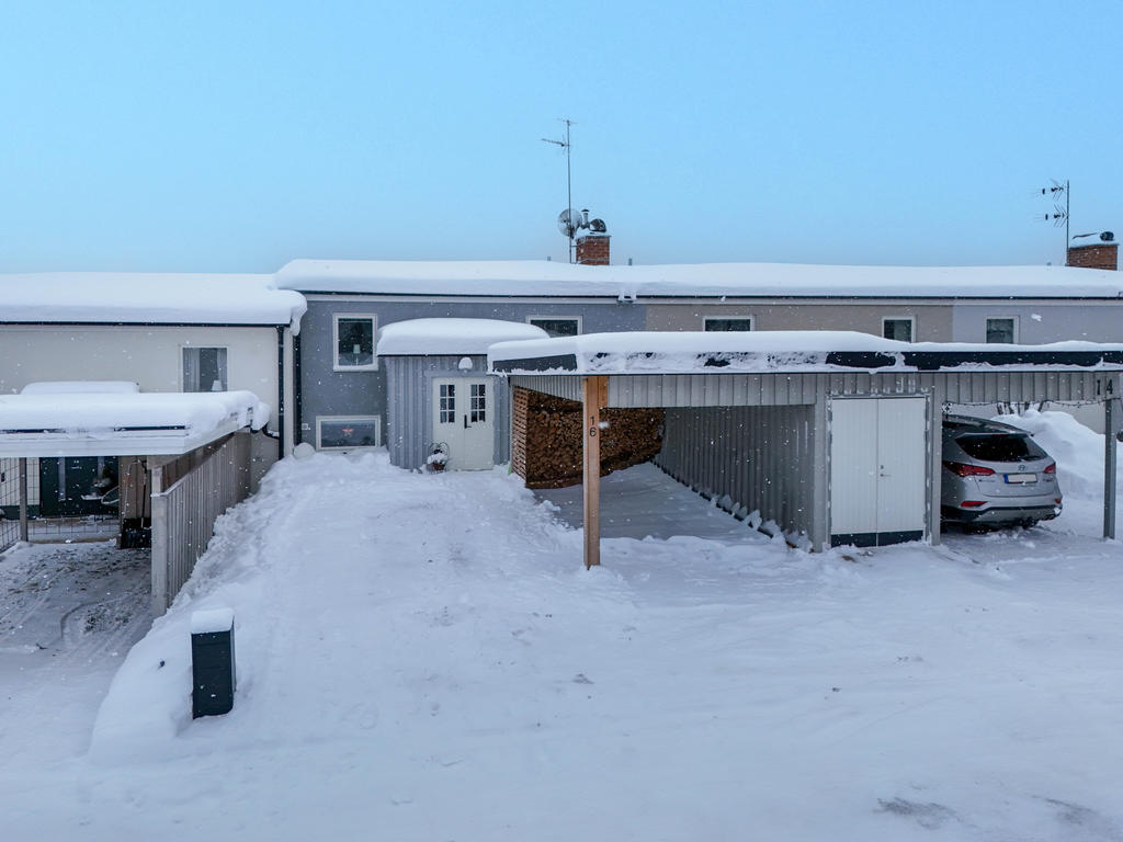 Carport med vedbod och gott om plats för att parkera en extra bil på tomten, framför entrén. 