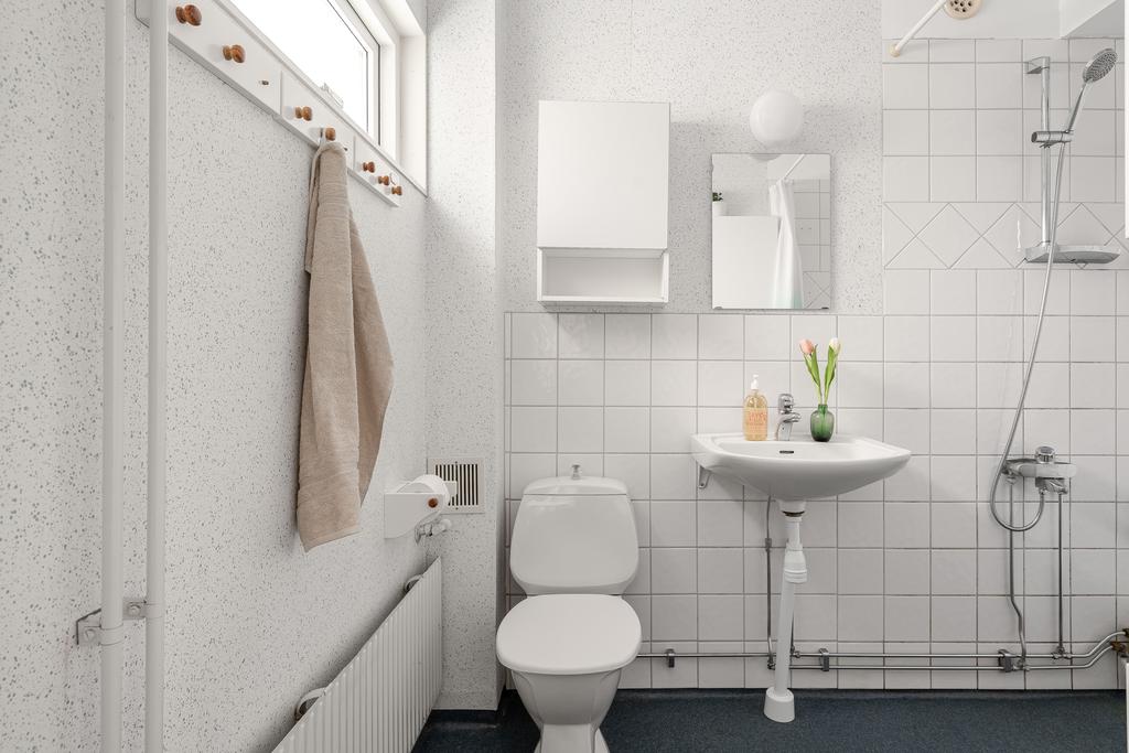 Duschrum med fönster och kaklad vägg vid dusch och handfat