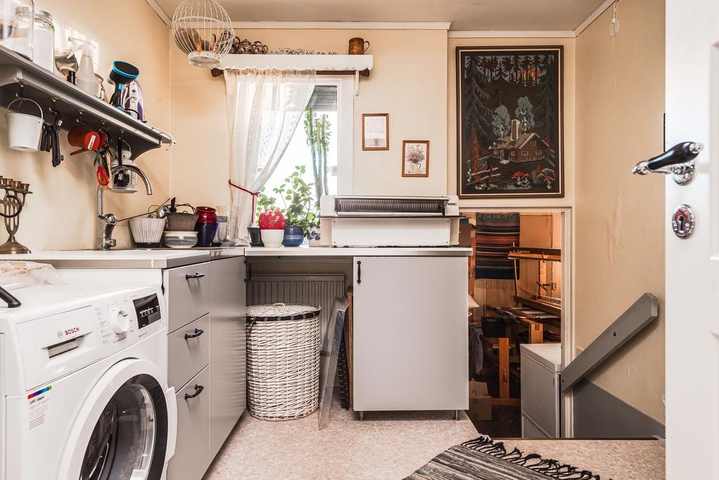 Tvättstuga med nedgång till förrådsrum och garage.