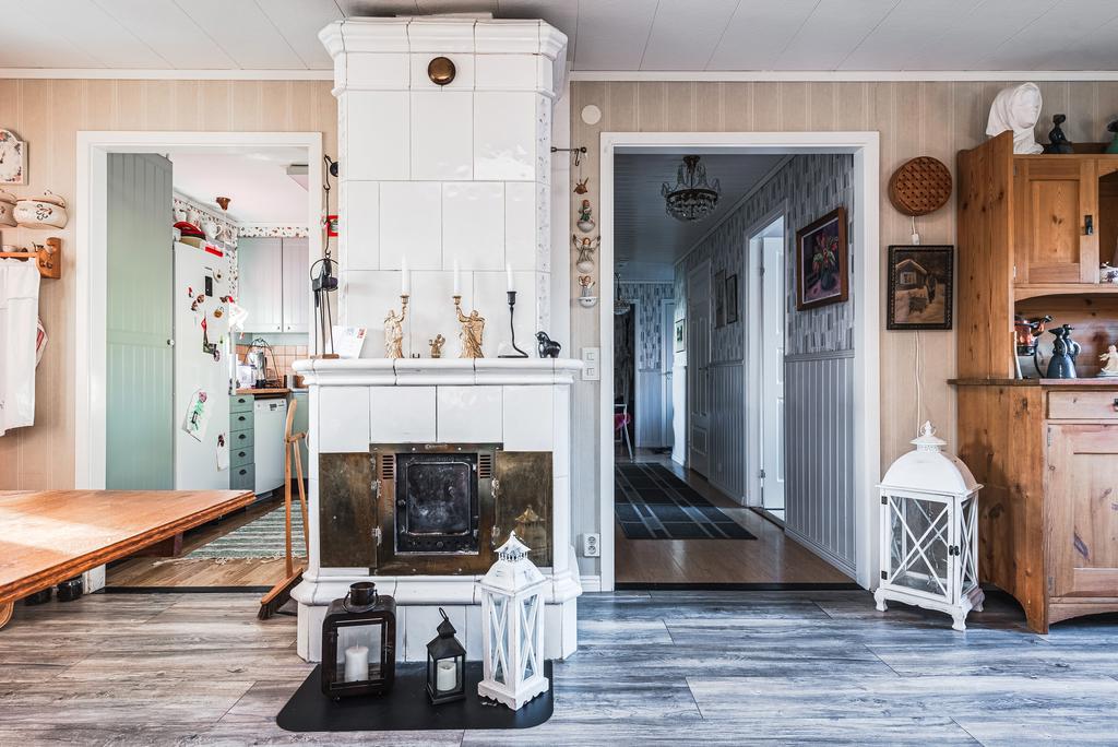 Tv-rum med ingång till kök samt plats för matgrupp. Eldstad.