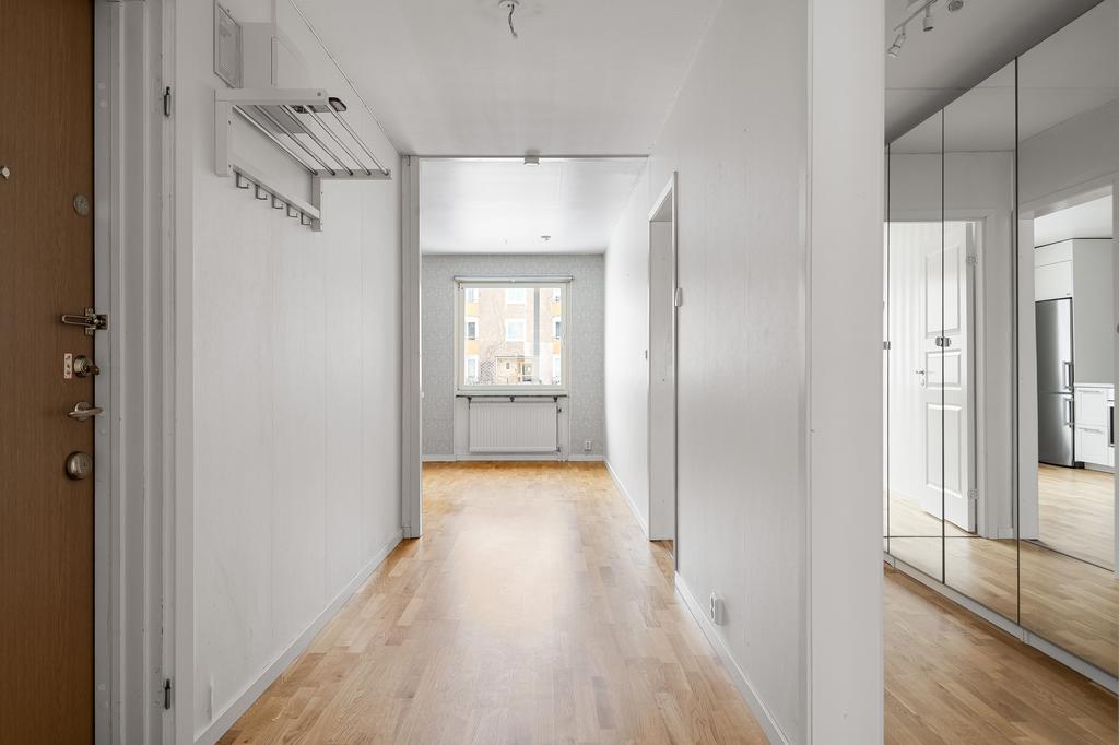 Välkommen in! Avhängning till vänster, här finns även en vägg som skärmar av garderoberna bakom så att planlösningen känns otroligt rymlig. 