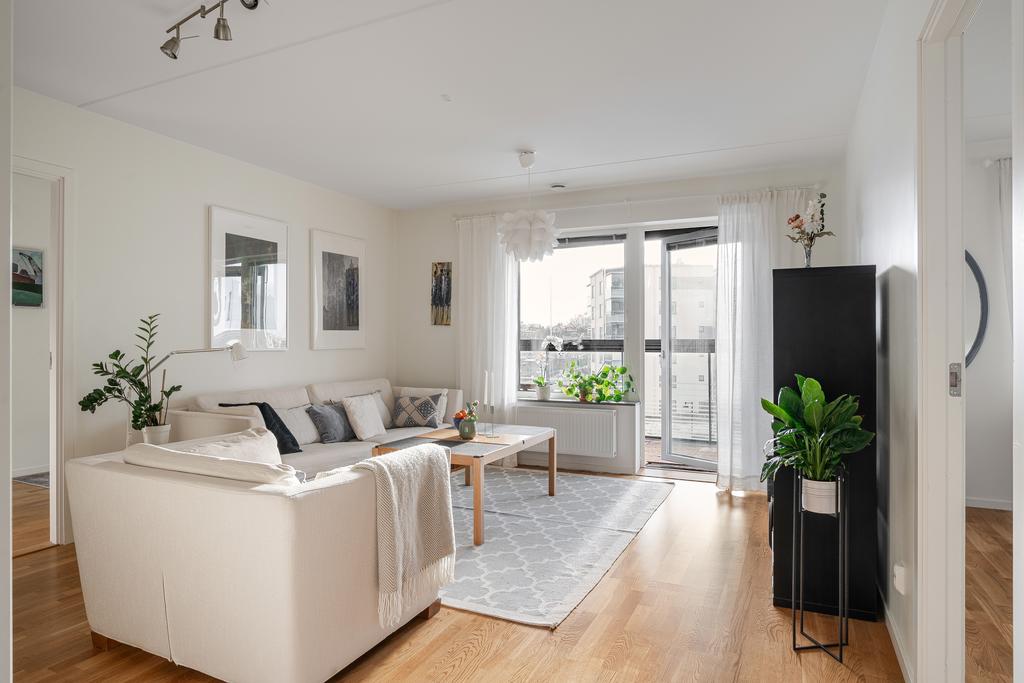 Stort vardagsrum med utgång till inglasad balkong